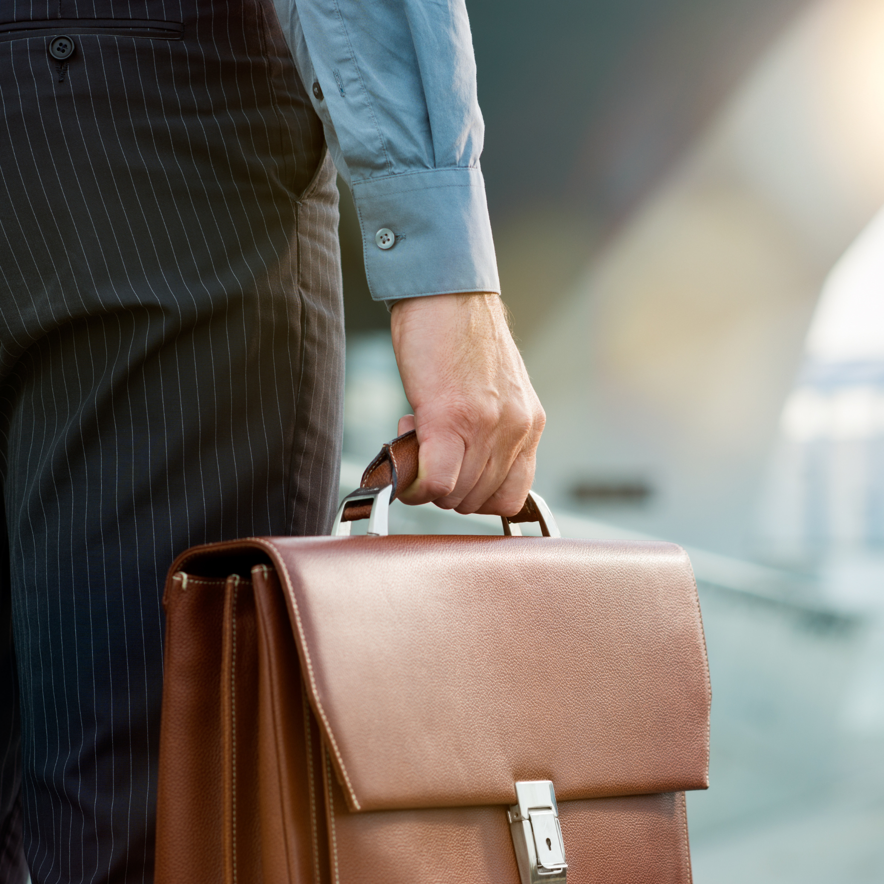 Homme d’affaires portant une mallette, symbolisant la préparation pour répondre à un appel d’offre public.